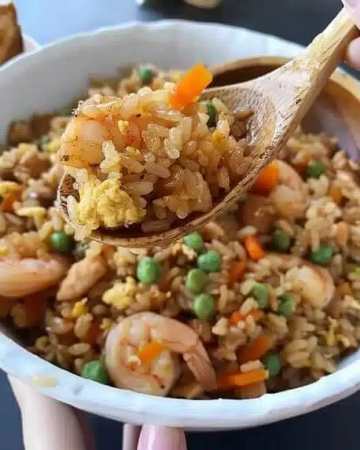 Shrimp fried rice served with yum yum sauce in a vibrant bowl.
