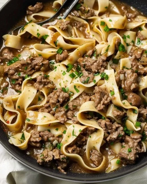 Delicious bowl of beef and noodles topped with green onions and sesame seeds