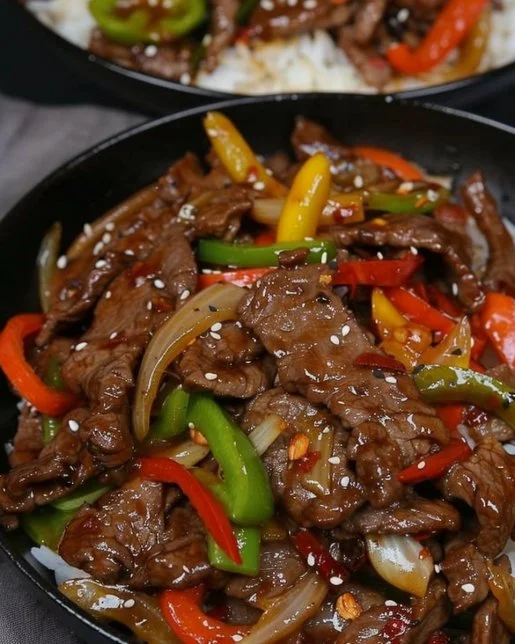 Colorful beef stir fry with fresh vegetables in a sizzling pan