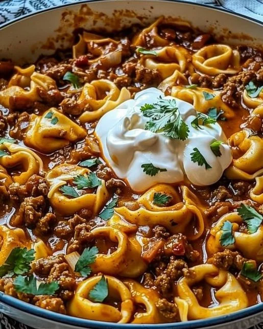 Cheesy Beef Enchilada Tortellini 2 Cheesy beef enchilada tortellini dish topped with melted cheese and garnished.