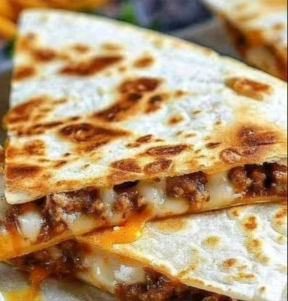 Cheesy Ground Beef Quesadillas 2 Cheesy ground beef quesadillas on a plate, garnished with salsa.