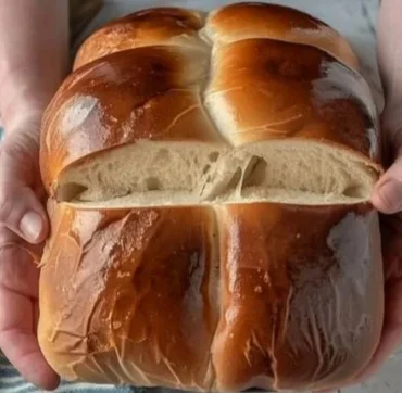 Freshly baked fluffy milk bread loaf on a wooden cutting board.
